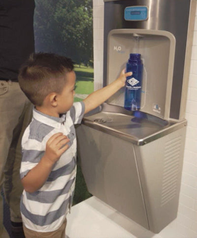 BFEZS168 EZReach™ Refrigerated Compact Surface Mounted Bottle Filler with a child demonstrating how easy it is to reach